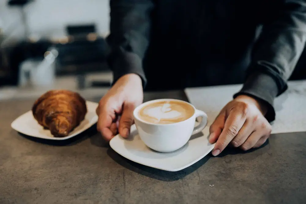 Latte and a croissant on a saucer